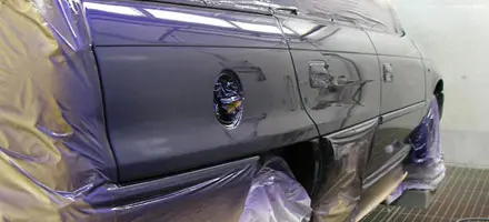 Verdecktes blaues Auto in der Lackiererei